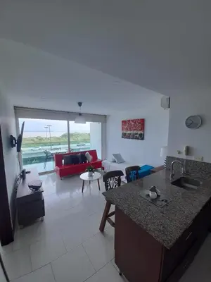 a kitchen and living room with a red couch at Edificio frente al mar con playas tranquilas in Cartagena de Indias