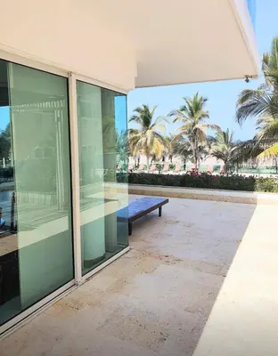 an empty building with a bench and palm trees at Vista directa al mar con amplia terraza y 3 habitaciones in Cartagena de Indias