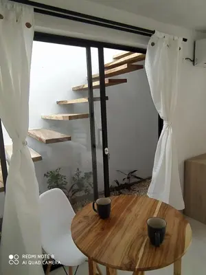 a table and two chairs in a room with a window at Casa Suite Palmar del viento FRENTE, FRENTE AL MAR by Amauna in Moñitos