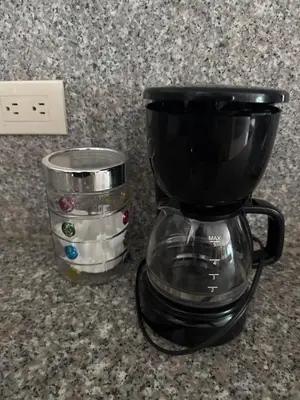 a coffee maker sitting on a counter next to a cup at Apartaestudio amplio in Barranquilla