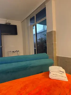 a room with a blue couch and a window at Apartaestudio amplio in Barranquilla