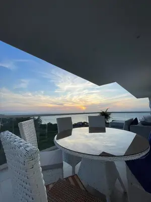 a table and chairs on a balcony with a view of the ocean at Loft de Lujo - Wifi, piscina y mar in Santa Marta