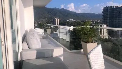 a balcony with white furniture and a view of a city at Loft de Lujo - Wifi, piscina y mar in Santa Marta