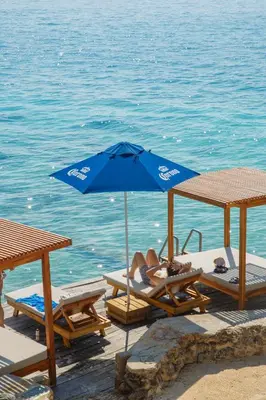 a woman laying on a chair under an umbrella on the beach at Hotel Isla Del Pirata in Isla del Pirata