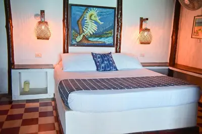 a bedroom with a bed with a painting on the wall at Hotel Isla Del Pirata in Isla del Pirata