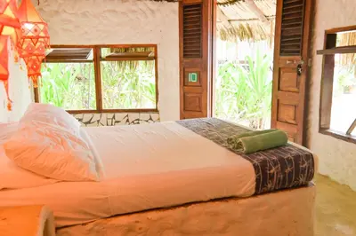 a bed in a room with a large window at Hotel Isla Del Pirata in Isla del Pirata
