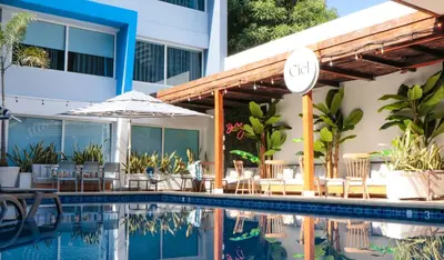a hotel swimming pool with chairs and an umbrella at The Blue Hotel in Cartagena de Indias