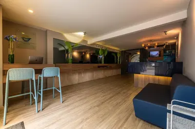 a lobby with a bar with chairs and a couch at The Blue Hotel in Cartagena de Indias