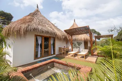 a villa with a swimming pool and a hut at AMALIFE Beach Club & Hotel in Tierra Bomba