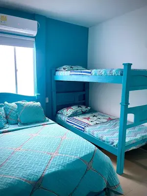 two bunk beds in a room with blue walls at San José Beach in Lomarena