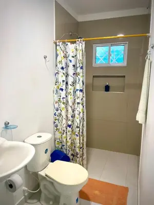 a bathroom with a toilet and a shower curtain at San José Beach in Lomarena