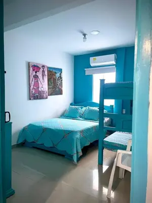 a blue bedroom with a bed and a chair at San José Beach in Lomarena