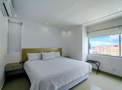 a bedroom with a bed and a large window at Atlantis Suites -Amoblados Nuevos sector Buenavista in Barranquilla