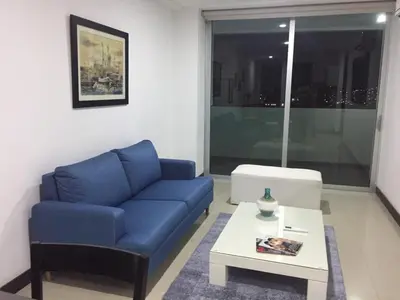 a living room with a blue couch and a coffee table at Atlantis Suites -Amoblados Nuevos sector Buenavista in Barranquilla