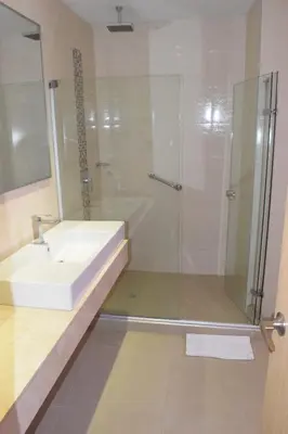 a bathroom with a sink and a glass shower at Radisson Diamond Barranquilla in Barranquilla