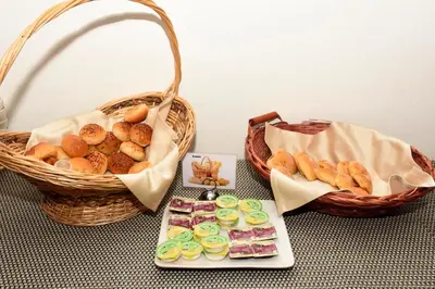 a table with two baskets of pastries and a plate of food at Radisson Diamond Barranquilla in Barranquilla