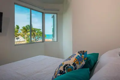 a bedroom with a bed with a view of the beach at Magico Apartamento Frente al Mar 2 Habitaciones B22B in Coveñitas