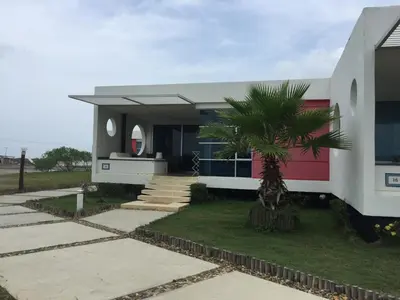 a house with a palm tree in front of it at Casa de Playa en Marina Puerto Velero in Barranquilla
