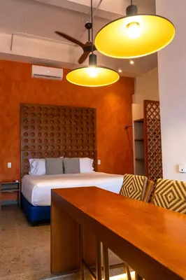 a bedroom with a bed and a table and yellow lights at Ganem Suites Cartagena in Cartagena de Indias
