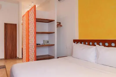 a bedroom with a white bed and a yellow wall at Ganem Suites Cartagena in Cartagena de Indias