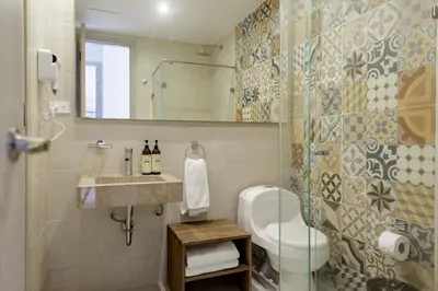 a bathroom with a toilet and a sink and a mirror at Ganem Suites Cartagena in Cartagena de Indias