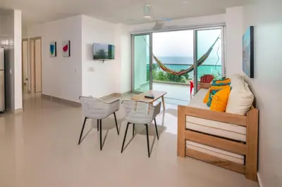 a living room with a couch and a table and chairs at Magico Apartamento Frente al Mar 3 Habitaciones AR44 in Coveñas