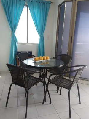 a dining room table with chairs and a table with oranges on it at Vista al mar en Edificio Mar Adentro Bocagrande in Cartagena de Indias
