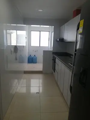 a white kitchen with two blue vases on the floor at Vista al mar en Edificio Mar Adentro Bocagrande in Cartagena de Indias