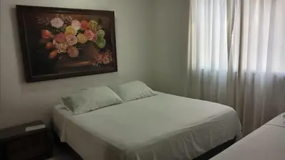 a bedroom with a bed with a painting on the wall at Vista al mar en Edificio Mar Adentro Bocagrande in Cartagena de Indias