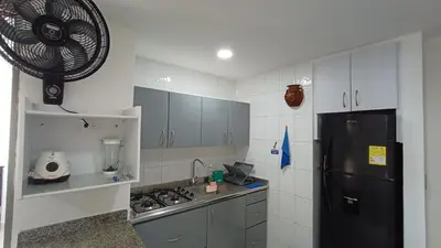 a kitchen with a black refrigerator and a stove at APARTA-SUITES EN CARTAGENA JUNTO a LA PLAYA in Cartagena de Indias