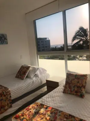 a bedroom with two beds and a large window at NUEVO PRECIOSO APARTAMENTO in Cartagena de Indias
