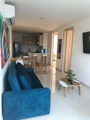 a living room with a blue couch and a kitchen at NUEVO PRECIOSO APARTAMENTO in Cartagena de Indias