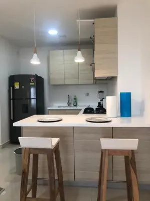 a kitchen with two stools and a black refrigerator at NUEVO PRECIOSO APARTAMENTO in Cartagena de Indias