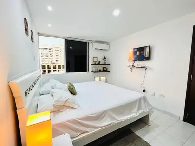 a white bedroom with a large bed and a window at Amazing ocean view Apartment in El Laguito Cartagena in Cartagena de Indias