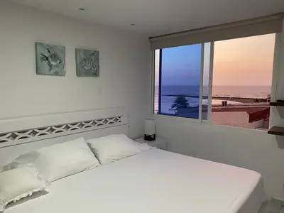a bedroom with a white bed and a large window at Amazing ocean view Apartment in El Laguito Cartagena in Cartagena de Indias