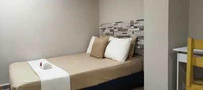 a bedroom with a bed with pillows on it at Hotel Gran Mendoza Inn Barranquilla in Barranquilla