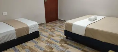 two beds sitting next to each other in a room at Hotel Gran Mendoza Inn Barranquilla in Barranquilla