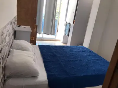 a bedroom with a bed with a blue blanket on it at Hotel Gran Mendoza Inn Barranquilla in Barranquilla