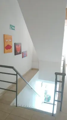 a staircase in a room with paintings on the wall at Hotel Gran Mendoza Inn Barranquilla in Barranquilla