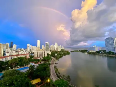 a rainbow in the sky over a city with a river at Loft playa y mar in Cartagena de Indias