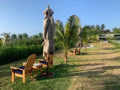 a group of chairs and a umbrella and a palm tree at Morros ío Serena Del Mar - RNT 95283-523 in Cartagena de Indias