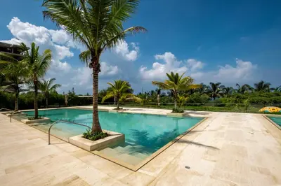 a swimming pool with a palm tree in the middle at Morros ío Serena Del Mar - RNT 95283-523 in Cartagena de Indias