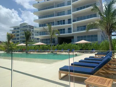 a swimming pool with lounge chairs and a building at Morros ío Serena Del Mar - RNT 95283-523 in Cartagena de Indias