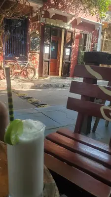 a drink sitting on a wooden bench next to a street at Casa Azulita RNT# 64888 in Cartagena de Indias