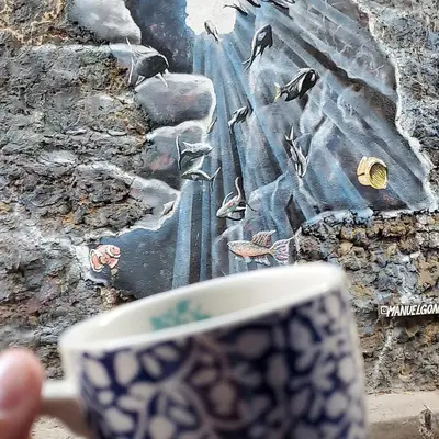 a hand holding a coffee cup with a picture of birds at Casa Azulita RNT# 64888 in Cartagena de Indias