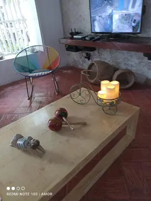 a living room with a table with candles and a chair at Casa Azulita RNT# 64888 in Cartagena de Indias
