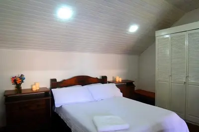 a bedroom with a bed with white sheets and two candles at Casa Azulita RNT# 64888 in Cartagena de Indias