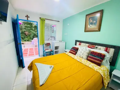 a bedroom with a yellow bed in a room at House Marfito Airport in Cartagena de Indias