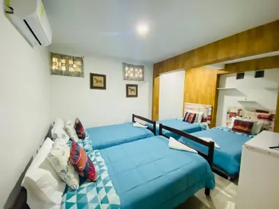 a bedroom with three beds with blue sheets at House Marfito Airport in Cartagena de Indias