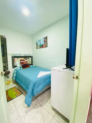 a bedroom with a blue bed and a television at House Marfito Airport in Cartagena de Indias